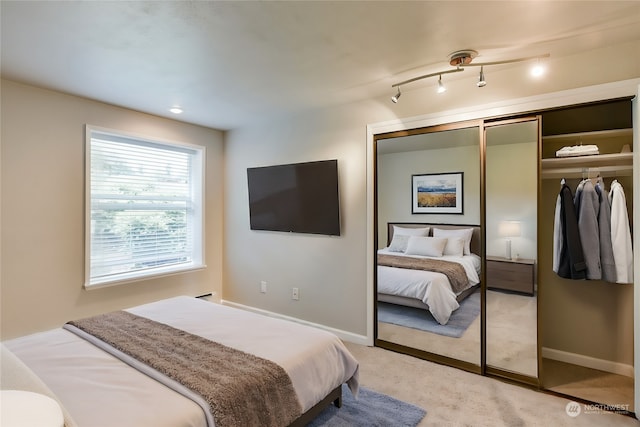 bedroom with light colored carpet and a closet