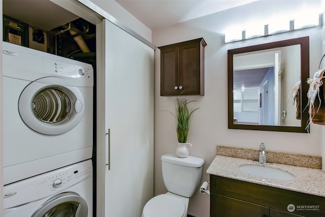 bathroom featuring stacked washer and dryer, vanity, and toilet