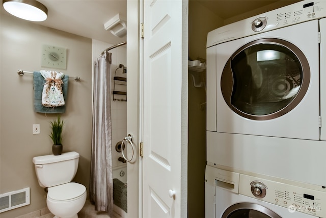 clothes washing area with tile patterned floors and stacked washer / drying machine