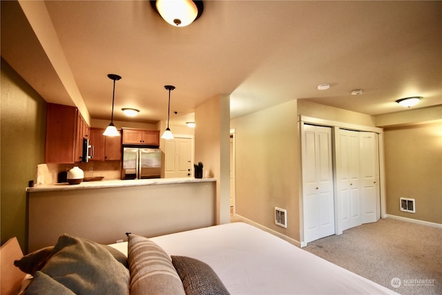 bedroom with stainless steel fridge and light carpet