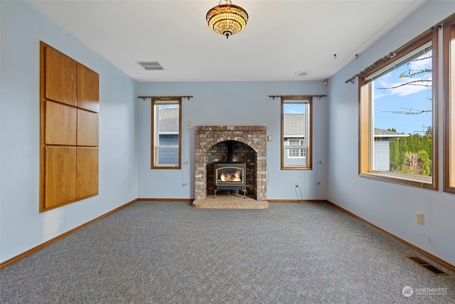 unfurnished living room featuring a wood stove and carpet floors