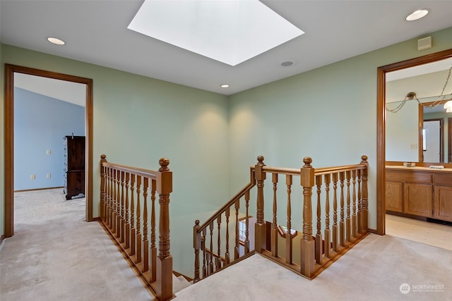 stairs featuring carpet, sink, and a skylight