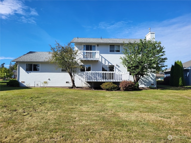 back of property with a wooden deck, a yard, and a balcony