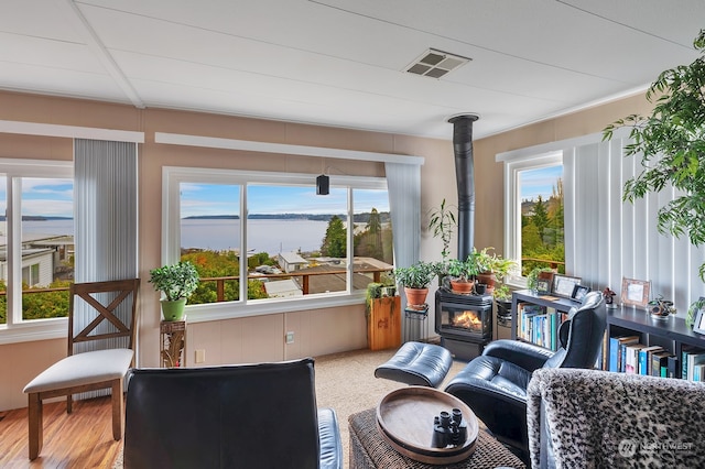 sunroom featuring a wood stove and plenty of natural light