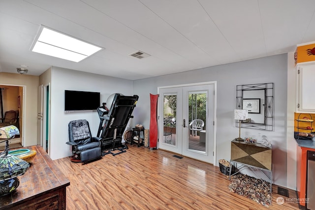 exercise area with french doors and light hardwood / wood-style floors