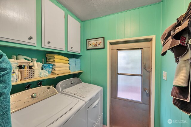 washroom with cabinets, independent washer and dryer, and a textured ceiling