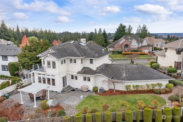 rear view of property featuring a lawn, a patio area, a balcony, and cooling unit