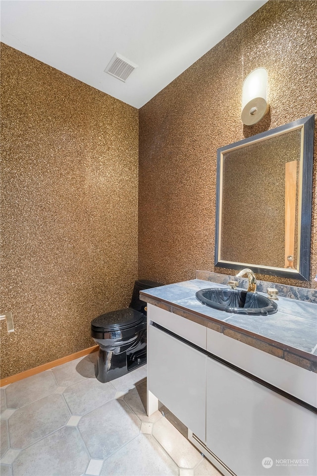 bathroom featuring tile patterned floors, vanity, and toilet