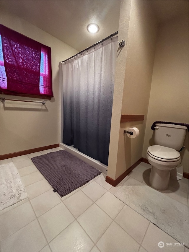 bathroom featuring tile patterned floors, toilet, and curtained shower