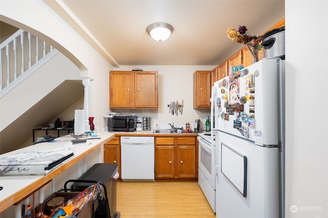 kitchen with white appliances, light hardwood / wood-style floors, and sink