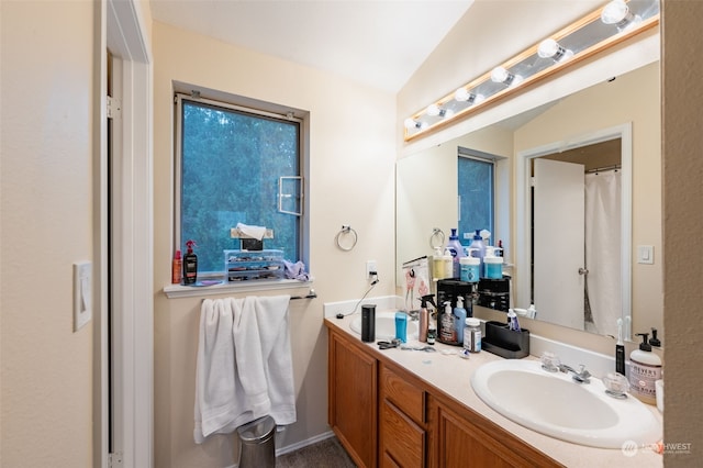 bathroom with vanity and vaulted ceiling