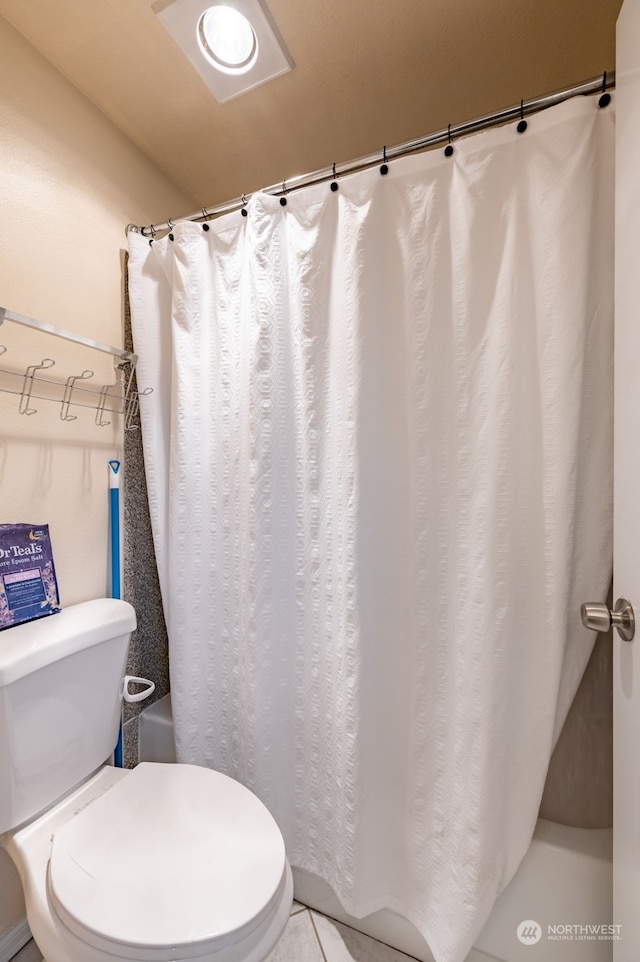 bathroom with toilet and tile patterned floors