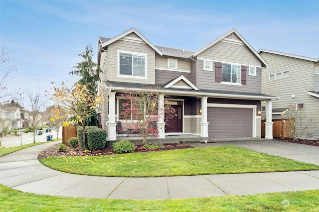 craftsman-style home featuring covered porch, a garage, and a front yard