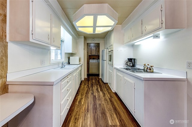 kitchen with appliances with stainless steel finishes, dark hardwood / wood-style flooring, sink, and white cabinets