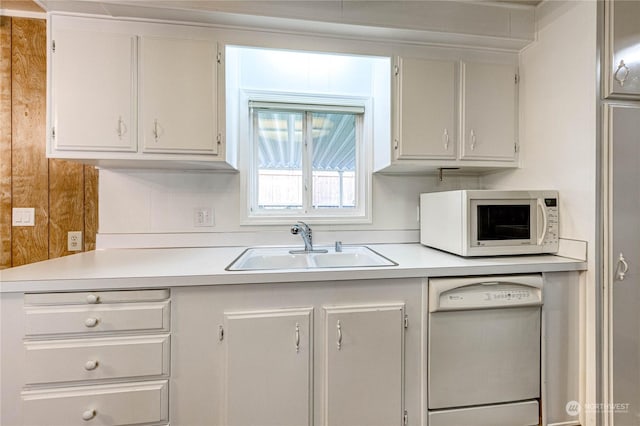 kitchen featuring sink, white appliances, and white cabinets