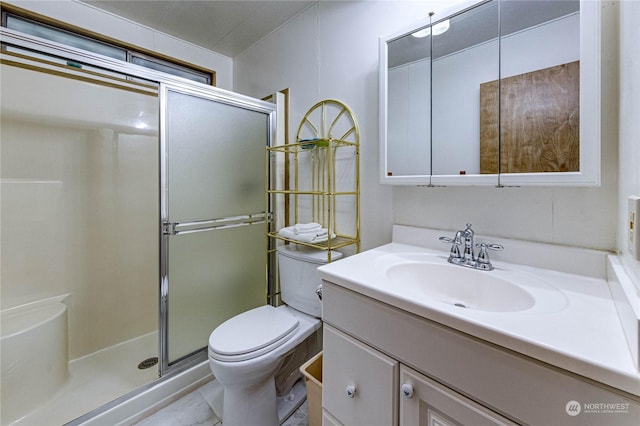 bathroom with vanity, a shower with door, and toilet