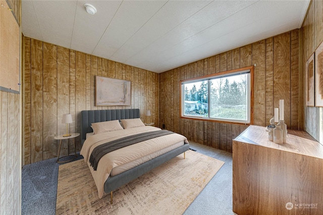 bedroom with wooden walls and light colored carpet