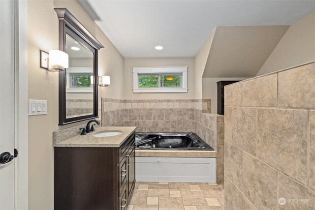 bathroom featuring vanity, tile walls, and a bathing tub