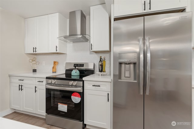 kitchen featuring wall chimney exhaust hood, light hardwood / wood-style floors, white cabinetry, and appliances with stainless steel finishes