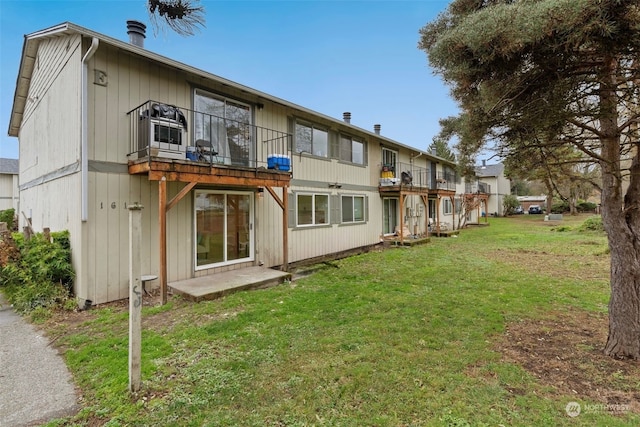 rear view of house featuring a lawn