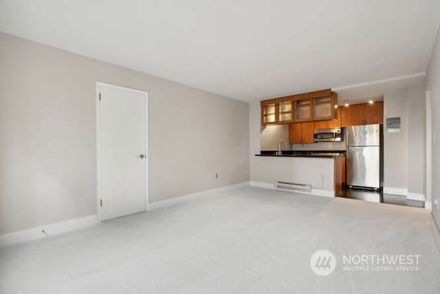 unfurnished living room featuring sink and light carpet