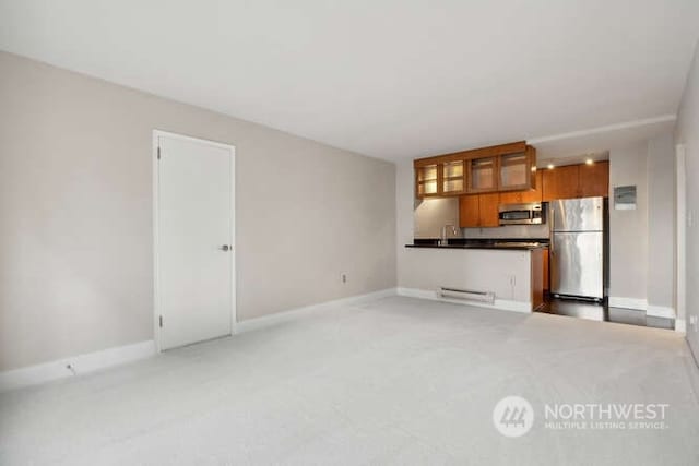 1105 Spring St Unit 701, Seattle, WA 98104 - unfurnished living room with light carpet, baseboards, a baseboard heating unit, and a sink