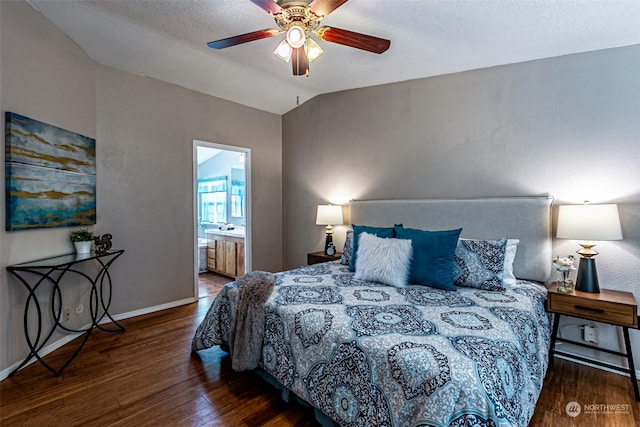 bedroom featuring ceiling fan, vaulted ceiling, dark hardwood / wood-style floors, and ensuite bath