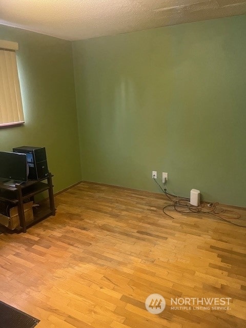 spare room featuring light hardwood / wood-style flooring and a textured ceiling