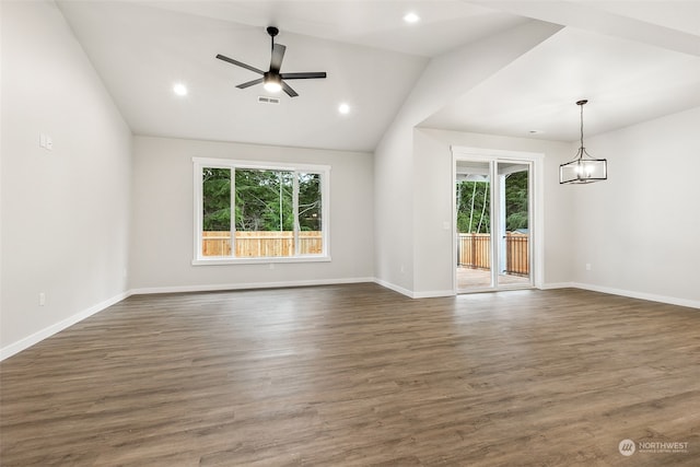 unfurnished living room with ceiling fan with notable chandelier, dark hardwood / wood-style floors, and lofted ceiling