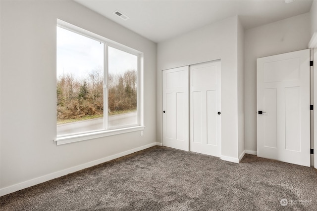 unfurnished bedroom with carpet, a closet, and multiple windows