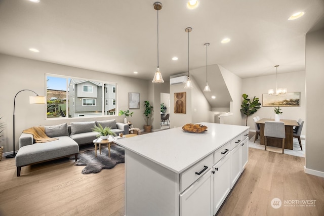 kitchen with a center island, decorative light fixtures, light wood-type flooring, a notable chandelier, and white cabinetry