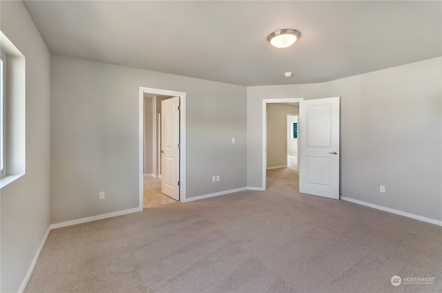 unfurnished bedroom featuring light carpet