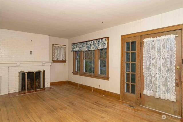516 SW Riverside Dr, Chehalis, WA 98532 - unfurnished living room featuring wood finished floors and a brick fireplace