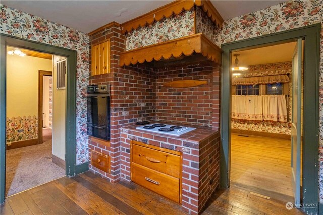 516 SW Riverside Dr, Chehalis, WA 98532 - kitchen with tile countertops, white electric stovetop, oven, dark wood-type flooring, and wallpapered walls