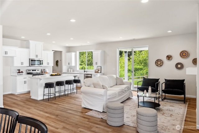 living room with sink and light wood-type flooring