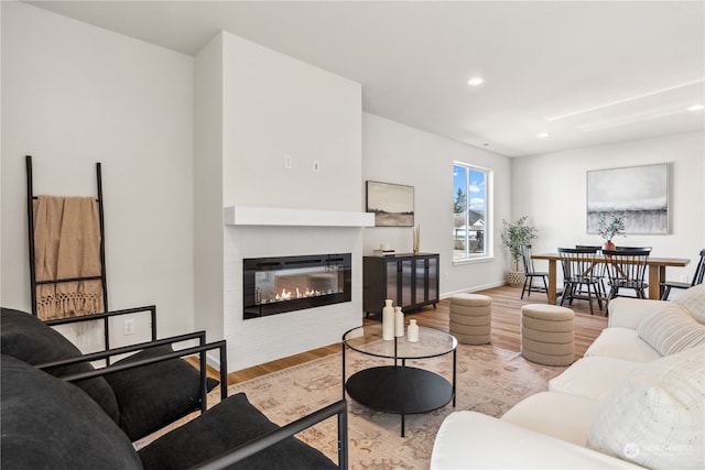 living room featuring a tile fireplace and light wood-type flooring