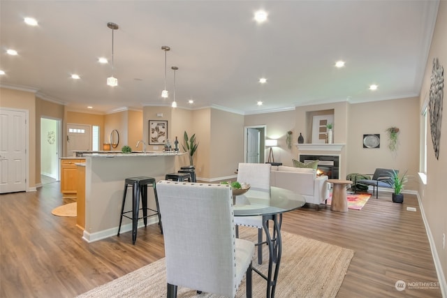 dining area with crown molding and light wood-type flooring