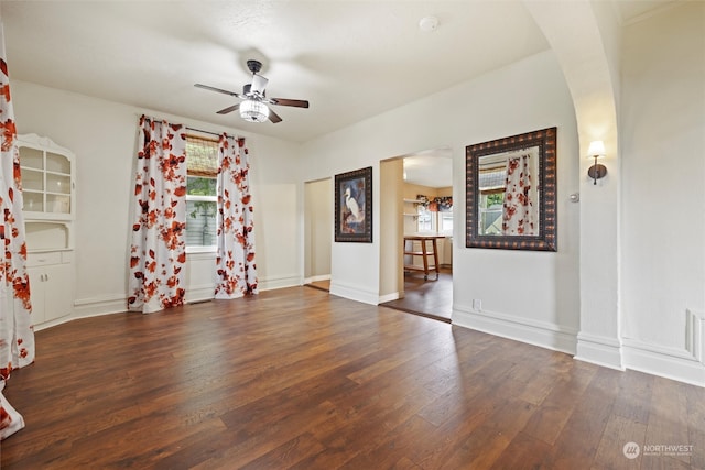 empty room with ceiling fan and dark hardwood / wood-style flooring