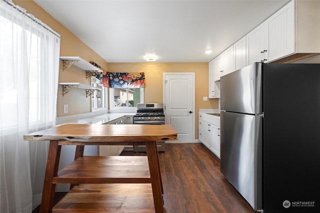 kitchen featuring white cabinets, appliances with stainless steel finishes, kitchen peninsula, and dark wood-type flooring