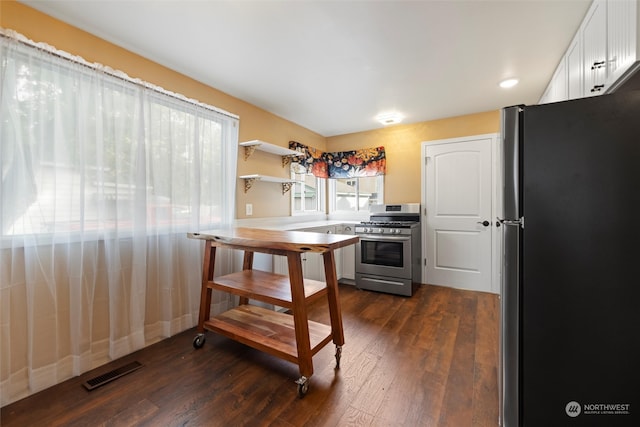 kitchen with white cabinets, appliances with stainless steel finishes, and dark wood-type flooring