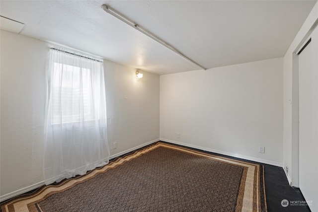 unfurnished room with dark carpet