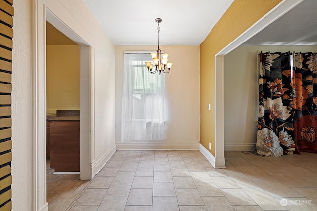 unfurnished dining area featuring light tile patterned flooring and an inviting chandelier