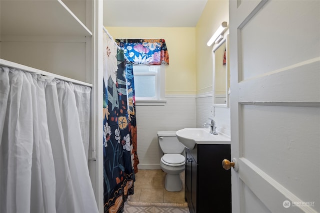 bathroom featuring tile patterned flooring, a shower with curtain, vanity, and toilet