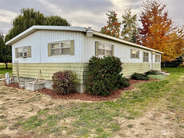 view of side of home featuring a lawn and cooling unit