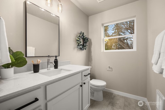 bathroom featuring tile patterned flooring, vanity, and toilet