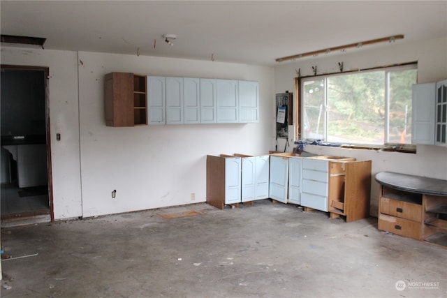 kitchen with white cabinetry and concrete floors