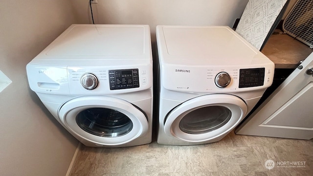 clothes washing area with washing machine and dryer