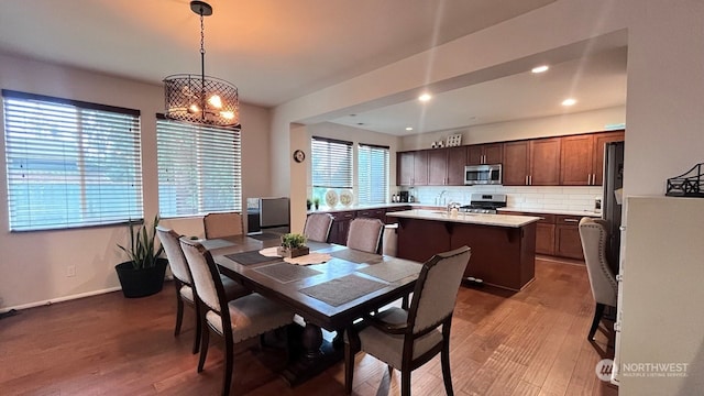 dining area featuring hardwood / wood-style flooring and an inviting chandelier