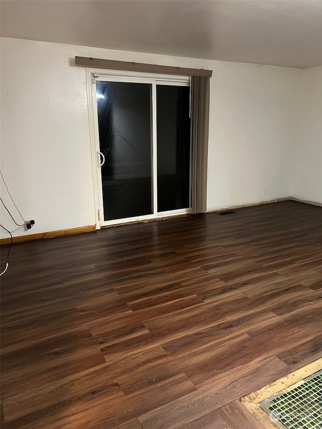 unfurnished room with dark wood-type flooring