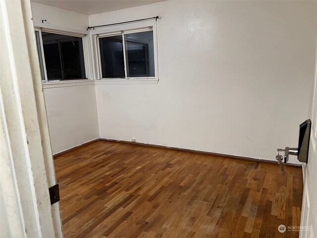 unfurnished room with dark hardwood / wood-style floors